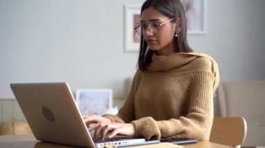 İnternette çalışan, dizüstü bilgisayarda yazan çekici Hintli melez kadın.