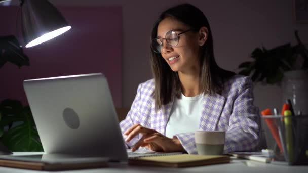 迷人的印度混血女人在晚上的办公室输入笔记本电脑键盘。在工作室的笔记本电脑上工作的女商人 — 图库视频影像