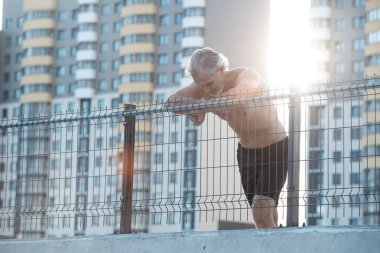 Yorgun Orta yaşlı adam dışarıda koştuktan sonra dinleniyor. Yakışıklı Koşucu Spor yaptıktan sonra mola veriyor