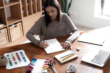 Ofisindeki masasında çalışan Hintli melez bir tasarımcı..