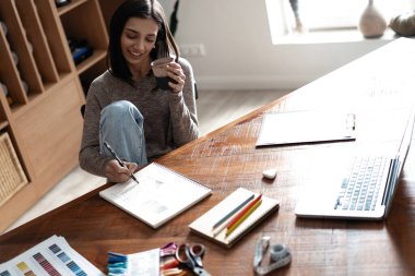 Ofisindeki masasında çalışan Hintli melez bir tasarımcı..
