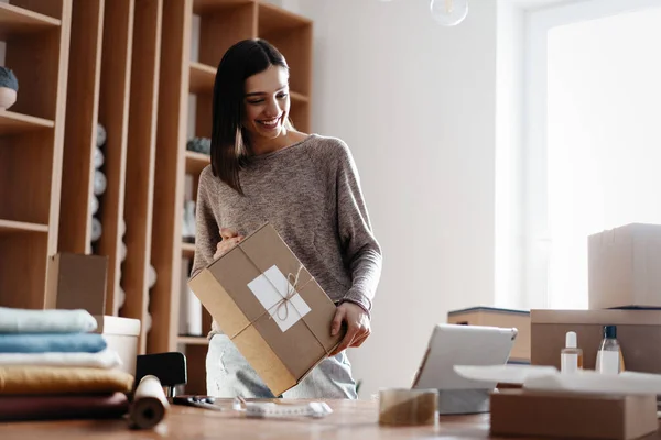 Indiase gemengde ras vrouwelijke verkoper met behulp van tablet controleren e-commerce kleding winkel bestellingen — Stockfoto