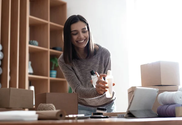 India mezclado-raza vendedor femenino usando tableta comprobación de comercio electrónico ropa tienda pedidos — Foto de Stock