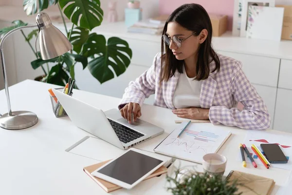 Indiana mestiça bela empresária trabalhando em um novo projeto em seu local de trabalho usando laptop no escritório. — Fotografia de Stock