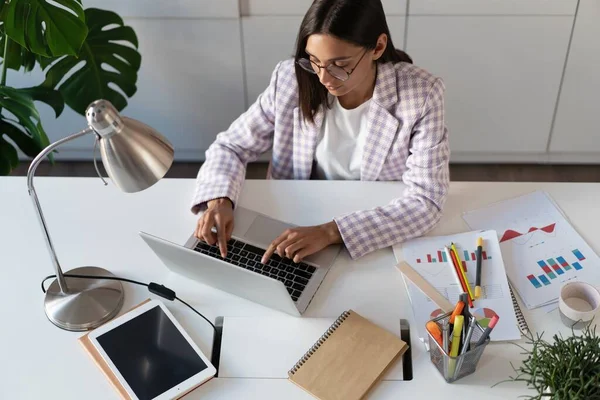 Glad ung indian blandras affärskvinna med hjälp av datorn tittar på skärmen arbetar på internet sitta vid skrivbordet — Stockfoto