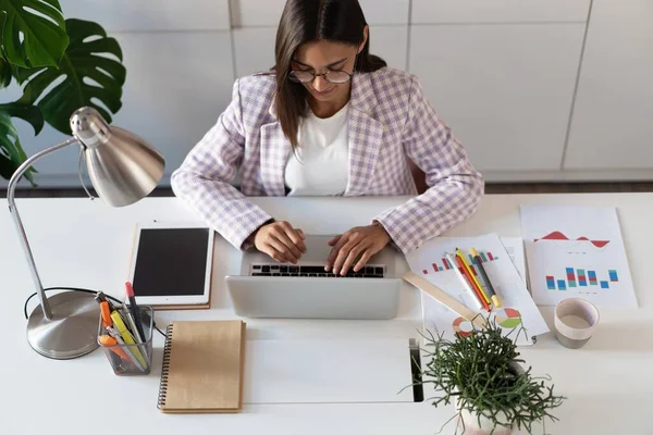 Jovem feliz indiana mestiça mulher de negócios usando computador olhando para a tela trabalhando na internet sentar na mesa de escritório — Fotografia de Stock