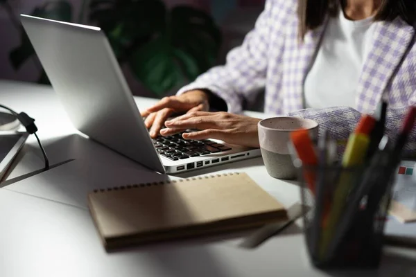 Perempuan menggunakan laptop saat mengerjakan ide proyek baru larut malam. Tangan wanita mengetik di papan ketik laptop — Stok Foto