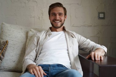 Orta yaşlı bir adam kanepede dinleniyor..