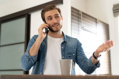 Kafkas 'lı genç adam sabah kahvesini fincandan içer. Arkadaşınla ya da meslektaşınla cep telefonundan konuşursun.