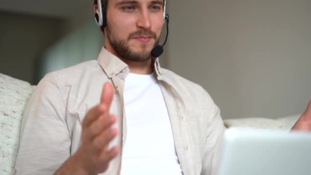 Młody sprzedawca utrzymujący połączenie wideo online z klientem, rozmawiający o obsłudze lub pomagający w zdalnym rozwiązywaniu problemów — Wideo stockowe