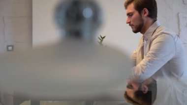Focused business man entrepreneur typing on laptop doing research, using computer sitting at home office desk