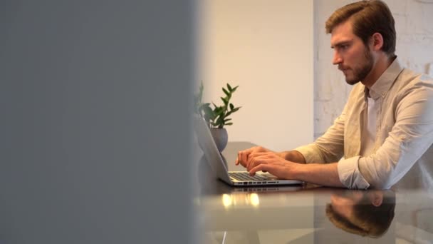 Focused business man entrepreneur typing on laptop doing research, using computer sitting at home office desk — Vídeos de Stock