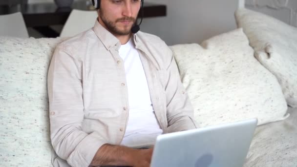 Freelancer using laptop device leaning on sofa at home, entrepreneur working distantly typing on notebook in apartment — Video Stock