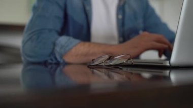 Evde bilgisayarda çalışan genç serbest çalışan bir adam. Günlük girişimci dizüstü bilgisayar üzerinde çalışırken yeni bir proje geliştiriyor