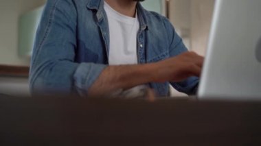 Evde bilgisayarda çalışan genç serbest çalışan bir adam. Günlük girişimci dizüstü bilgisayar üzerinde çalışırken yeni bir proje geliştiriyor