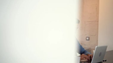 Evde bilgisayarda çalışan genç serbest çalışan bir adam. Günlük girişimci dizüstü bilgisayar üzerinde çalışırken yeni bir proje geliştiriyor