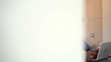 Evde bilgisayarda çalışan genç serbest çalışan bir adam. Günlük girişimci dizüstü bilgisayar üzerinde çalışırken yeni bir proje geliştiriyor