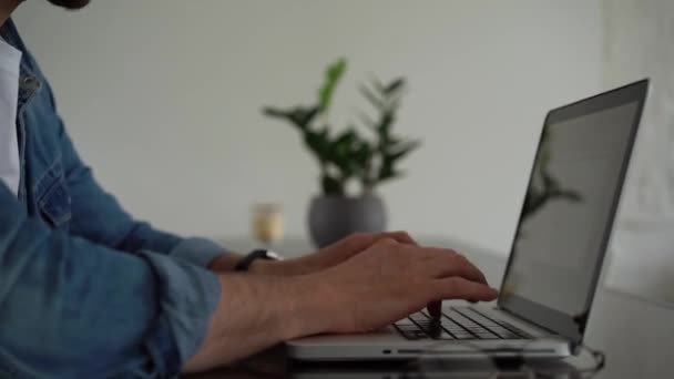 Jeune homme indépendant travaillant sur ordinateur à la maison. Entrepreneur occasionnel développer un nouveau projet tout en travaillant sur un ordinateur portable — Video