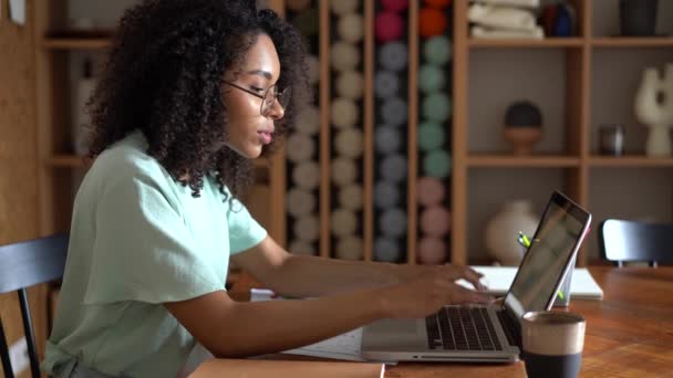 Denken mixed-race zakenvrouw werken op laptop computer in kantoor interieur — Stockvideo