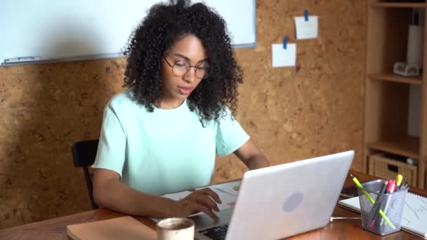 Pensando mulher de negócios de raça mista trabalhando no computador portátil no interior do escritório — Vídeo de Stock