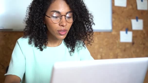 Pensando a una donna d'affari di razza mista che lavora sul computer portatile negli interni degli uffici — Video Stock