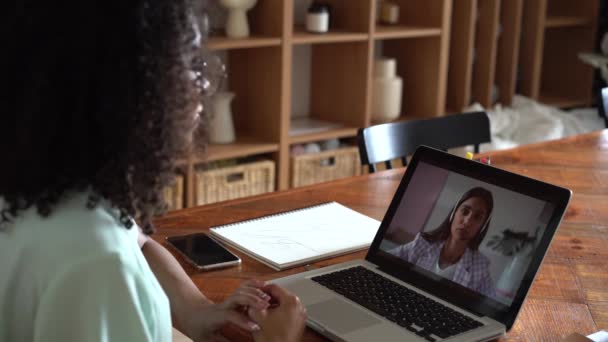 Feliz mujer de raza mixta que se comunica por conferencia telefónica hablar mirando a la computadora en la oficina — Vídeos de Stock