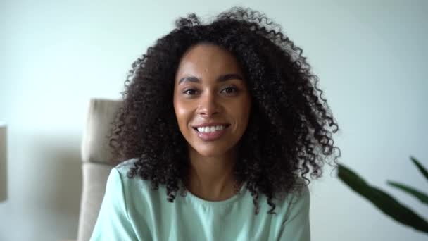 Mixte-race souriant jeune femme regardant la caméra à la maison, posant pour un portrait rapproché à l'intérieur. — Video