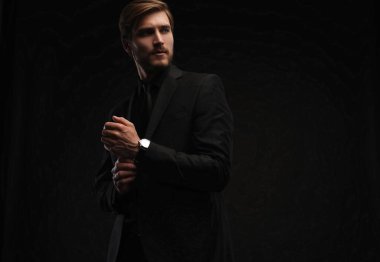 Siyah takım elbiseli zarif genç adam. Stüdyo moda portresi