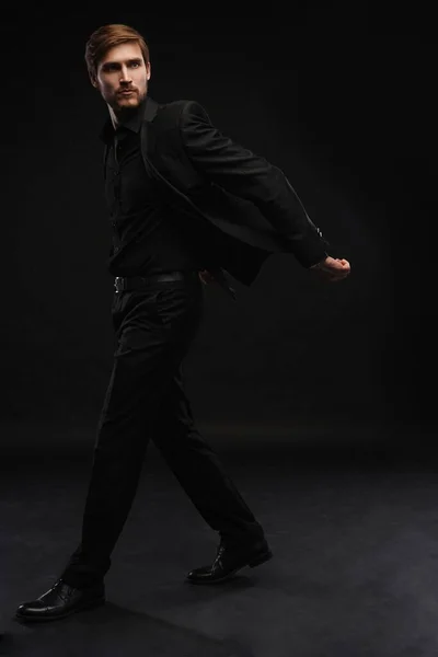 Young man in black suit full body portrait against black background. — Stock Photo, Image