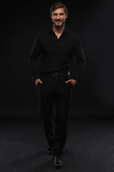 Молодий чоловік у чорному костюмі портрет повного тіла на чорному тлі . — стокове фото