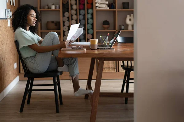 Femme d'affaires afro-américaine millénaire lisant du papier sur son lieu de travail au bureau. — Photo