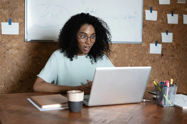 Mulher de raça mista alegre rir usando laptop vídeo stream conferência chamada, assistir webinar Imagem De Stock