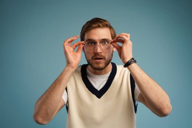 Sersemlemiş genç sakallı adam kameraya şaşkınlıkla bakıyor, olumsuz haberlerle şaşkına dönüyor.