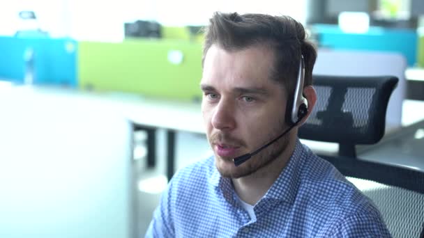 Mężczyzna przedstawiciel call center agent w bezprzewodowy zestaw słuchawkowy pomagający klientowi, operator pracujący w obsłudze klienta — Wideo stockowe
