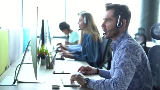 Agente di call center rappresentativo maschile in cuffia wireless che aiuta il cliente, operatore che lavora nel servizio di assistenza clienti — Video Stock