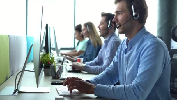 Mies edustaja Call Center agentti langattomat kuulokkeet auttaa asiakasta, operaattori työskentelee asiakastukipalvelu — kuvapankkivideo