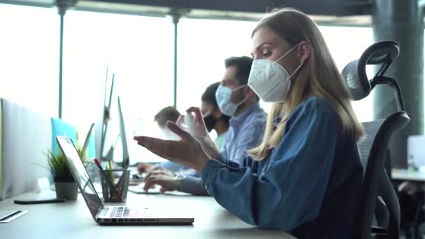 Wanita bisnis muda mengenakan masker wajah membersihkan tangan dengan gel pembersih — Stok Video