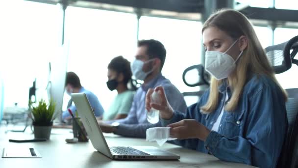 Mujer con máscara facial médica limpieza ordenador teclado sentado en el lugar de trabajo de la oficina — Vídeo de stock