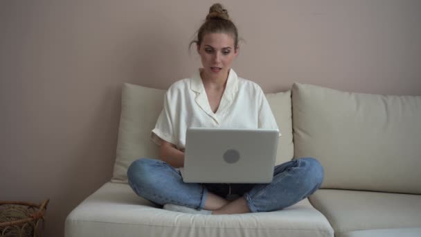 Happy young woman make video call online chat look at laptop screen sit on sofa — Stock Video