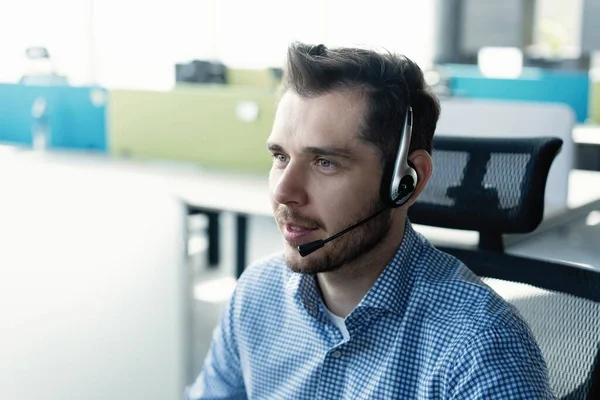 Ung stilig manlig kundsupport telefonoperatör med headset arbetar i callcenter — Stockfoto