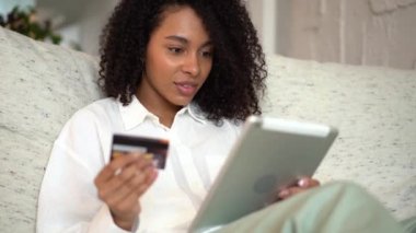 Tablet, kredi kartı, e-ticaret interneti kullanan melez bir kadın.
