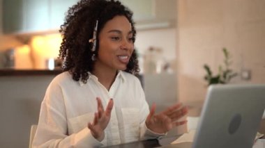 Çevrimiçi video konferansı ile iletişim kuran kulaklık takan karışık ırklı kadın.