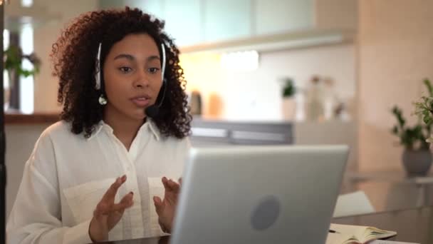 Mixed race woman wearing headphones communicating by videocall online conference — 비디오