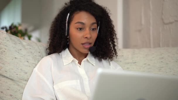 Smiling mixed race woman video calling for job interview using laptop at home — ストック動画