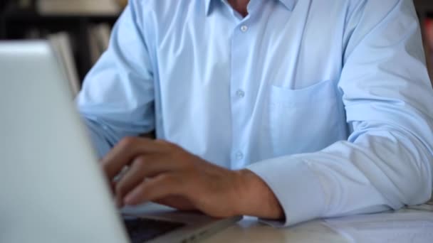 Vážný dospělý muž pracující se svým notebookem v kanceláři. — Stock video