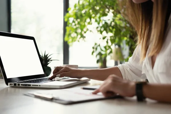 Linda analista de dados do sexo feminino sentado na mesa funciona em um laptop. Mulher elegante no ambiente de escritório moderno. — Fotografia de Stock