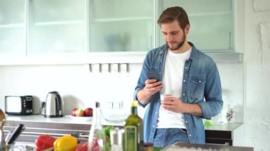 Evde akıllı telefon kullanan çekici bir adam mesaj gönderiyor.