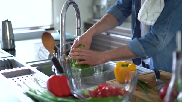 Mutfakta, Adam Sağlıklı Yemek Pişiriyor. Sebzeleri musluk suyuyla yıkayan adam. — Stok video