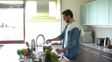 Mutfakta beyaz bir adam yemek pişiriyor. Yemek pişirmek için malzemelerin hazırlanması
