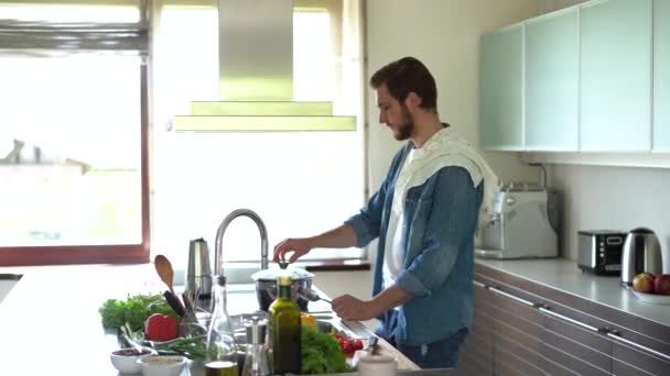 Vit man lagar mat i köket. Beredning av ingredienser för matlagning — Stockvideo